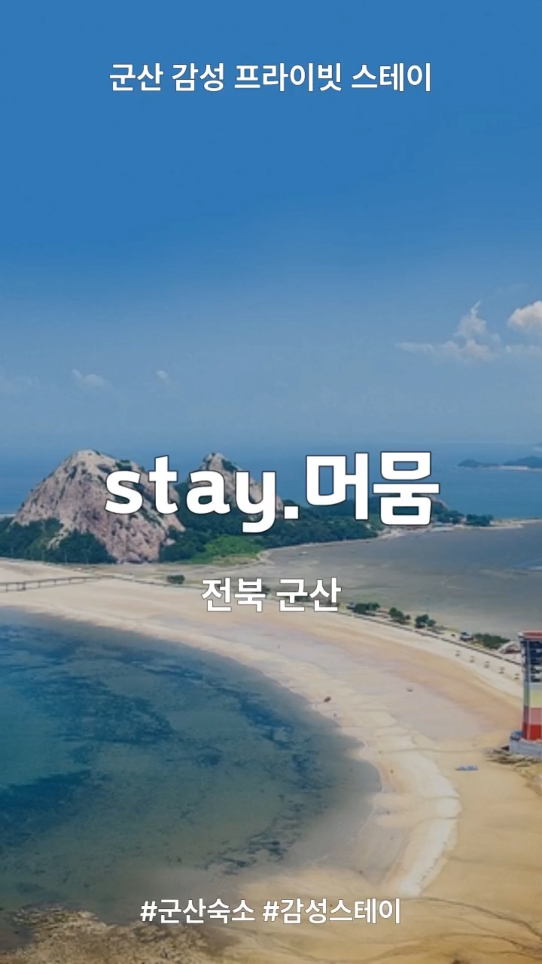 해변과 푸른 바다, 멀리 보이는 산 풍경이 펼쳐진 전경입니다.